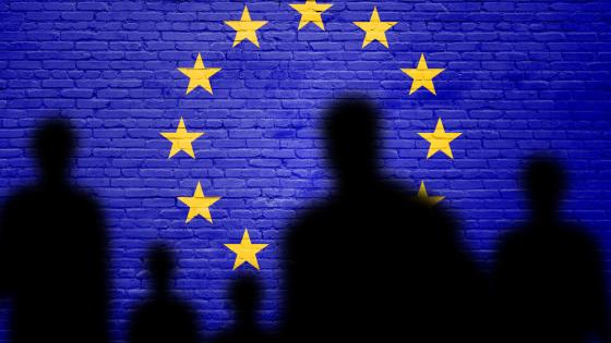  Silhouette of immigrants in front of EU flag